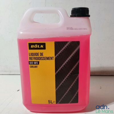 une bouteille rose contenant un liquide, posée sur une table
