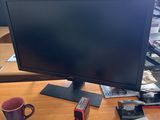 a computer monitor sitting on top of a wooden desk