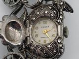 a silver clock that is sitting on top of a table