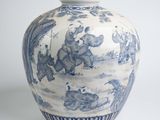 a blue and white vase with a picture of people on it