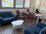 an image of a living room with blue couches and a white coffee table