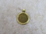 a close up of a gold plated pendant on a white surface