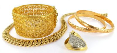 two gold rings, a bracelet, and a ring on a white background