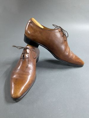 men ' s brown leather shoes with laces on a gray surface