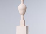 une sculpture blanche posée sur un socle blanc