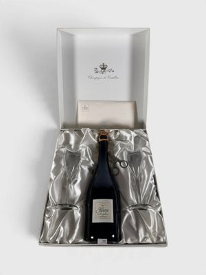une bouteille de champagne dans un coffret cadeau, posée sur une surface blanche