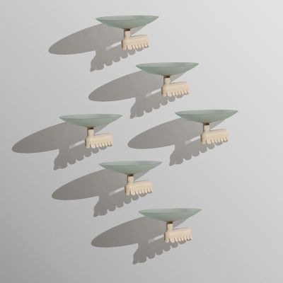 Plusieurs brosses à cheveux blanches sont disposées en rangée sur une surface blanche