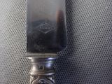 a silver knife that is sitting on top of a table