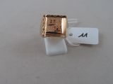 a gold ring on a white surface with a price tag