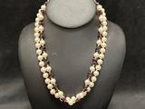 a necklace with pearls and garnets on a mannequin