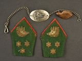 two green and gold embroidered patches with gold stars and a silver coin