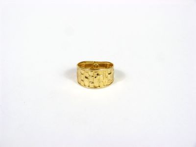 une bague en or posée sur une surface blanche, avec un fond blanc
