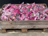 a wooden crate filled with pink lollipops on a sidewalk