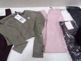 three pairs of pants and a sweater sitting on a table