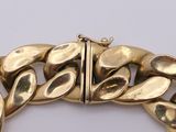 an image of a gold bracelet on a white surface