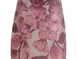 purple glass vase with flowers and butterflies on it on a white background