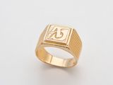 gros plan d'une bague en or sur une surface blanche