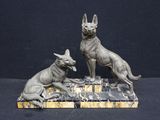 statue of two dogs sitting on a marble base on a black background