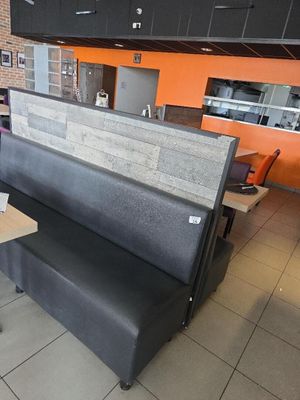 des tables et des bancs dans un restaurant aux murs orange et au sol carrelé