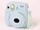 a small blue camera with a string attached to it