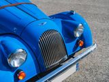 a close up of a blue car with a brown stripe on the front
