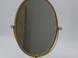 a small gold mirror on a stand with a tag on it
