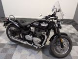 une moto noire garée sur un sol à damier