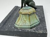 a statue of a dog sitting on top of a bell