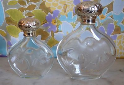 deux flacons de parfum posés l'un à côté de l'autre sur une table