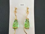 a pair of earrings with green glass and gold wire