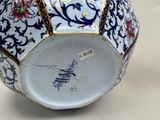 a blue and white vase with a gold border on it