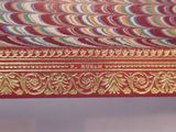 a picture of a red and gold table with a clock on it