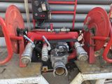 a red fire hydrant sitting next to a stack of pipes