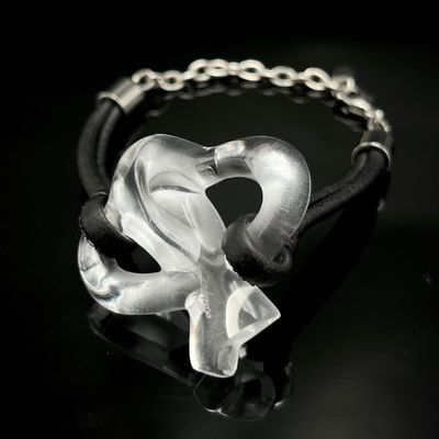 un bracelet en cuir noir orné d'un cœur en verre transparent
