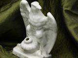 a white statue of an angel on a green cloth