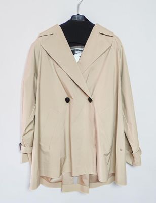 a beige coat hanging on a hanger on a white wall