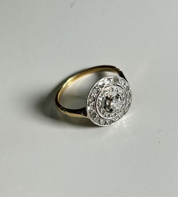 a close up of a gold and diamond ring on a white surface