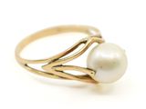 gros plan d'une bague en perle sur une surface blanche