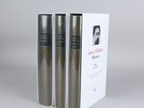 three books in a white box on a grey background