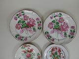 three plates with flowers painted on them are sitting on a table