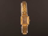 an image of a gold watch on a black surface
