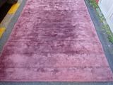 purple area rug on the ground in front of a car
