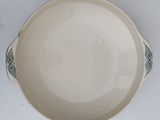 a white bowl with a green design on it