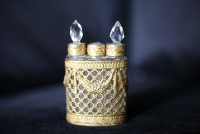 un bougeoir en or surmonté de deux bougies en cristal