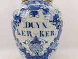 a blue and white jar with a gold lid