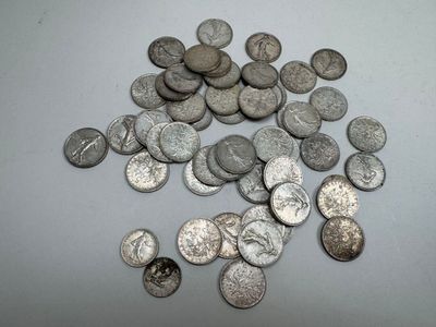 some silver coins are scattered on a white surface