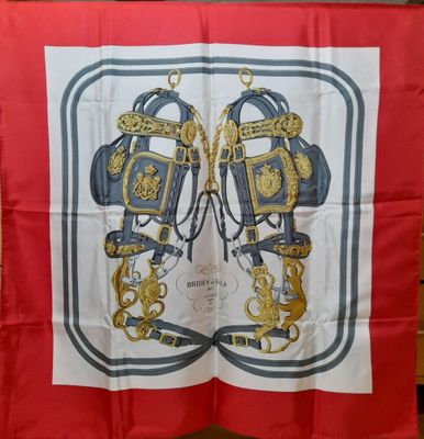 un gros plan d'une écharpe rouge et blanche ornée d'un motif doré et bleu