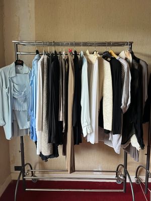 a lot of clothes hanging on a rack in a room