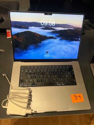 a laptop computer sitting on a desk with a charger on it