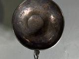 a metal pan hanging from a hook on a wall